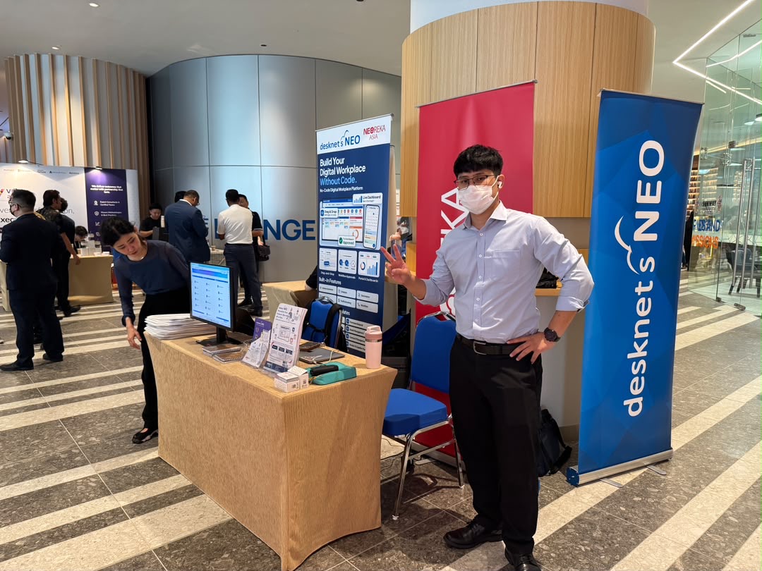 NEOREKA ASIA team at the booth with desknet's NEO banners and a live demo screen at IA Business Summit 2026