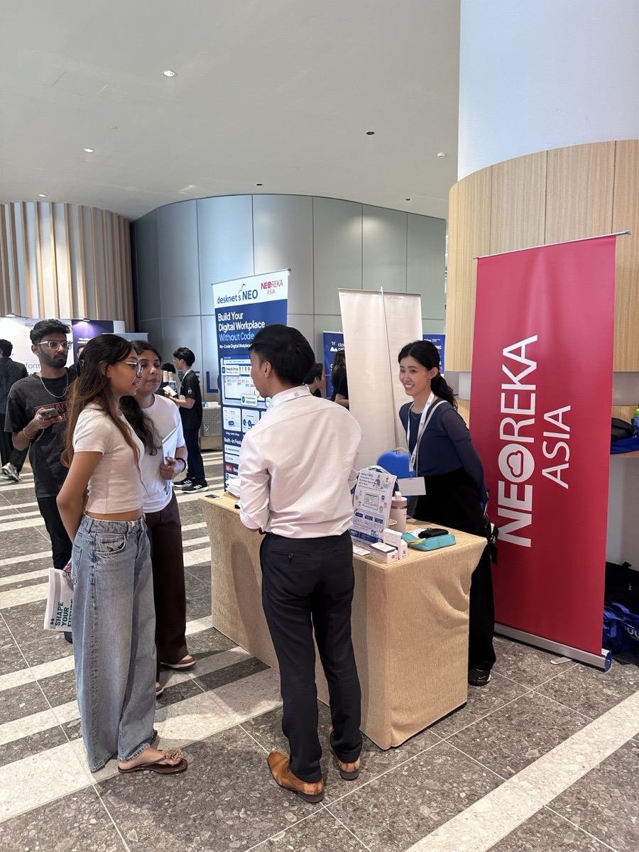 NEOREKA ASIA team members speaking with summit attendees at the booth